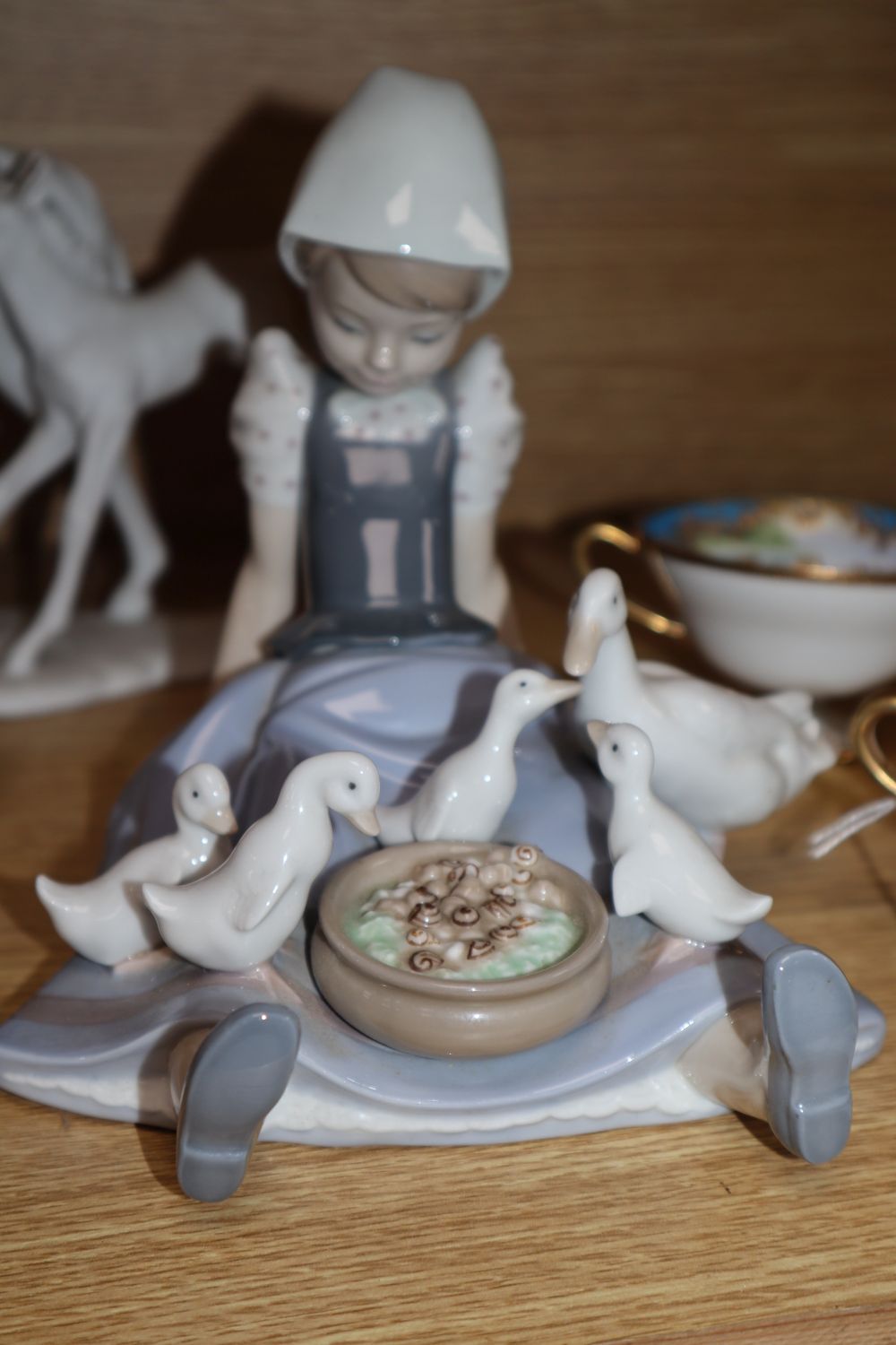 Four Noritake teacups and a Lladro girl with ducks, etc.